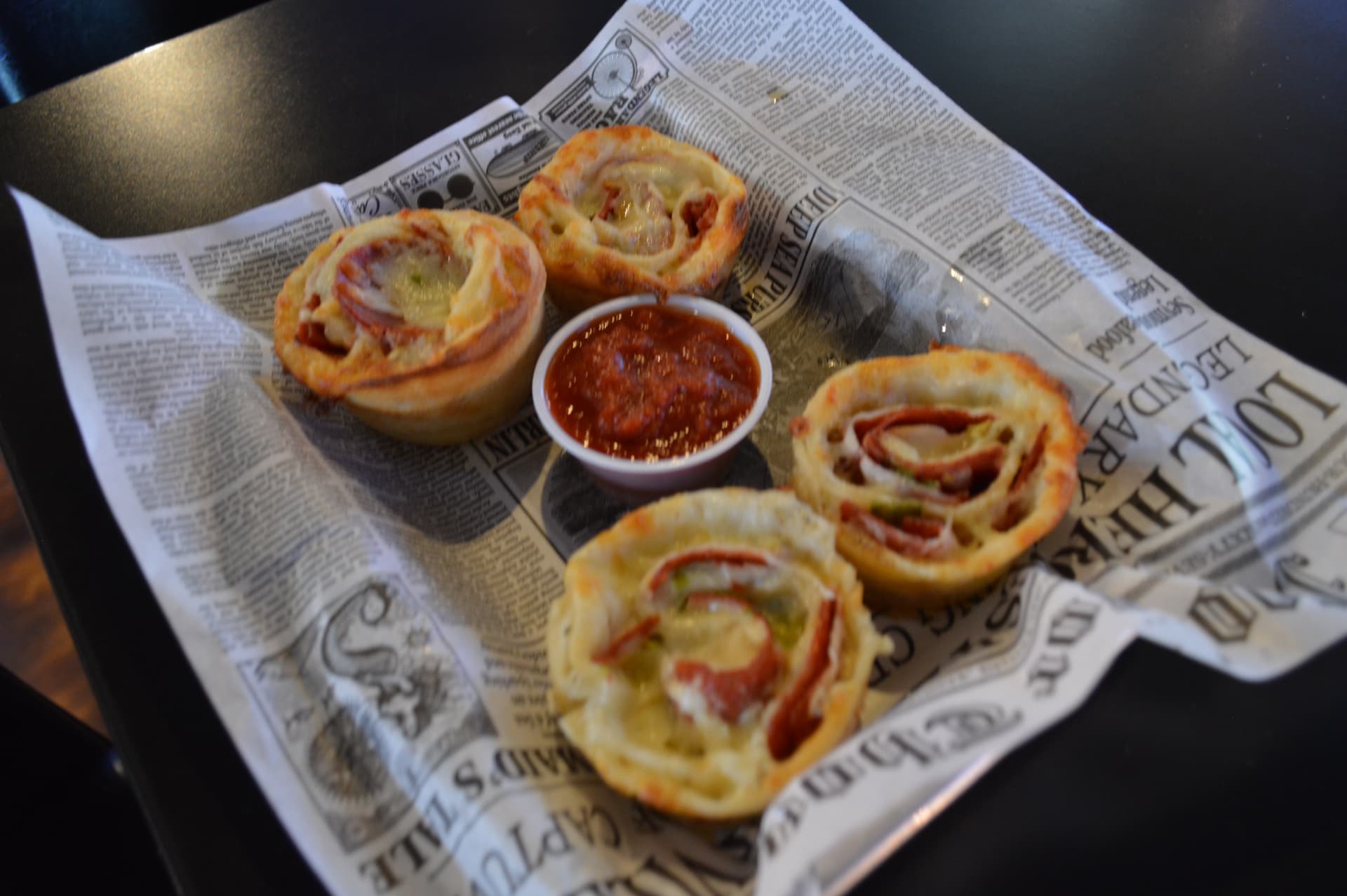 Baked pepperoni rolls with mozzarella and a cup of marinara dipping sauce